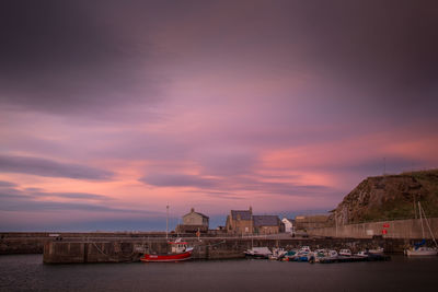 Boats at harbor during sunset