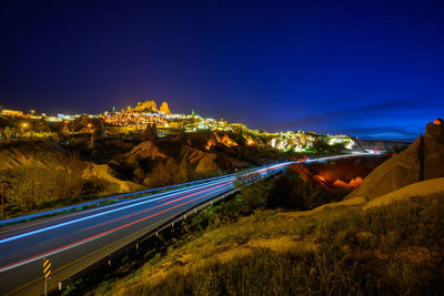 Light trails on road against sky at night