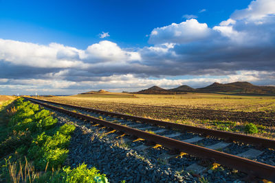 View of railroad tracks on field against sky