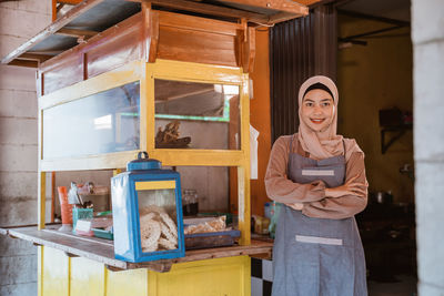 Portrait of smiling woman by food stall