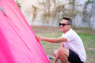 Man arranging tent on land