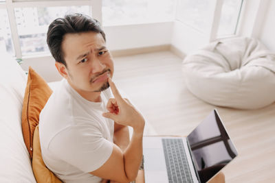 High angle portrait of man with laptop at home