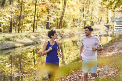 Couple jogging on autumnally forest track