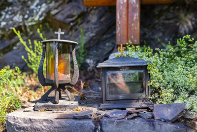 Two metal candles with glass sides standing in a chapel on a mountain trail.