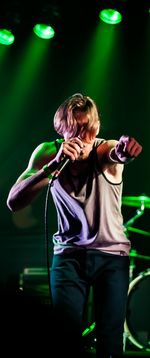 Young man singing while holding microphone on stage