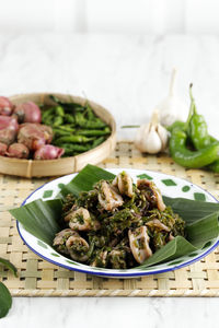 Cumi cabe ijo, stir fry squid with green pepper, shallot, and garlic. served on enamel plate