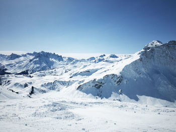 Scenic view of snowcapped mountains against clear blue sky