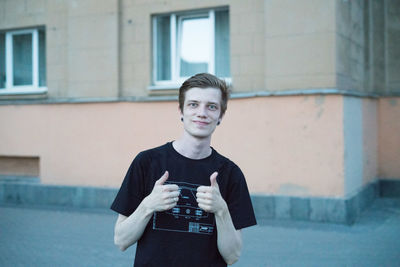 Portrait of a young man drinking glass outdoors