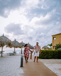 People standing on beach against sky