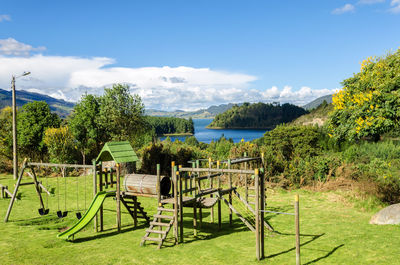 Playground by embalse del neusa against sky on sunny day