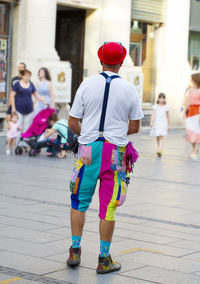 Rear view of men walking on street in city