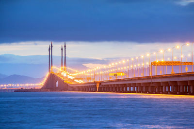 View of bridge over sea against cloudy sky