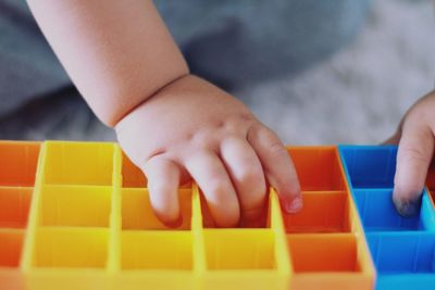 Close-up of boy baby hand playing with toy