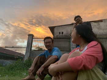 People sitting against orange sky