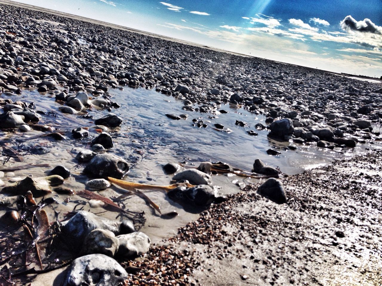 beach, sea, shore, sky, pebble, sand, stone - object, tranquil scene, scenics, horizon over water, tranquility, nature, water, beauty in nature, rock - object, surface level, sunlight, cloud - sky, stone, cloud