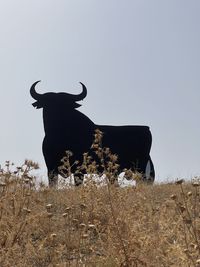 View of cow on field against clear sky