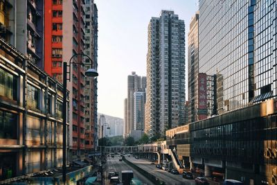 Cars on street amidst buildings in city against sky
