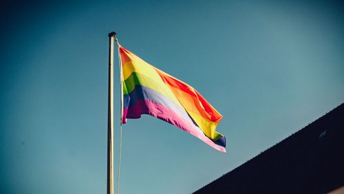 Low angle view of flag against clear blue sky