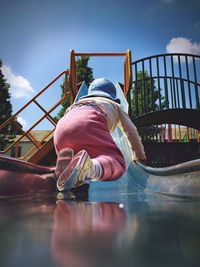 Rear view full length of child on slide at playground