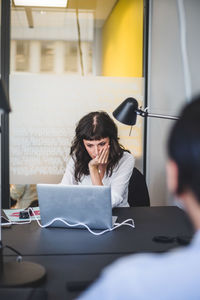 Creative businesswoman using laptop at desk in office