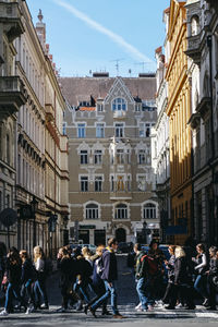 People on street in city against sky