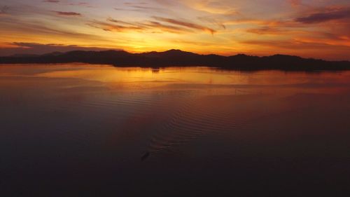 Scenic view of lake against romantic sky at sunset