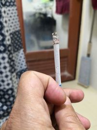 Close-up of hand holding cigarette