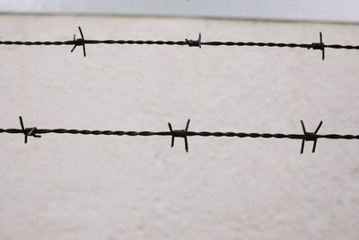 Close-up of barbed wire against sky