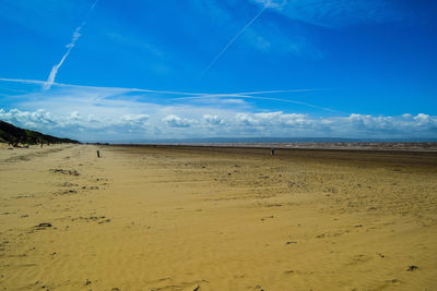 Scenic view of beach against blue sky