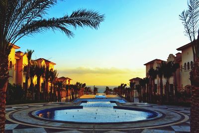 Panoramic view of swimming pool by buildings against sky