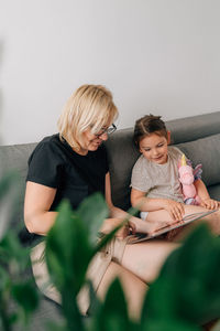 Young woman using laptop while sitting on sofa at home