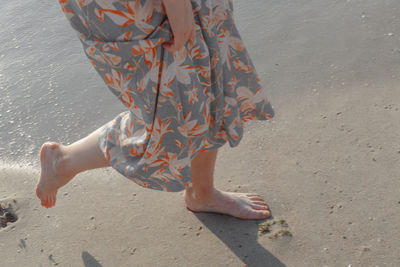 Low section of woman walking at beach