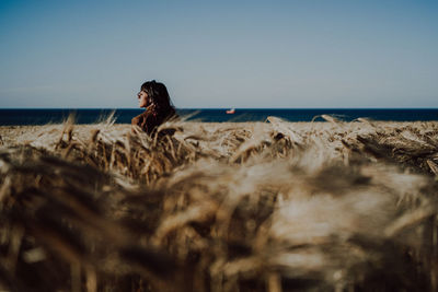 Rear view of woman at beach against clear sky