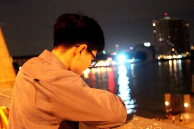 Boy looking at illuminated night