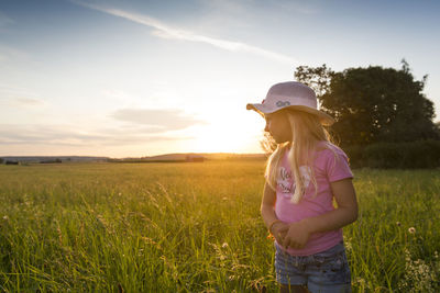 Full length of girl on field against sky during sunset