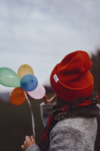 Rear view of women standing on balloons against sky