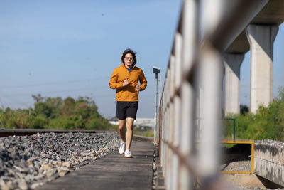 Full length of man on railroad tracks against sky