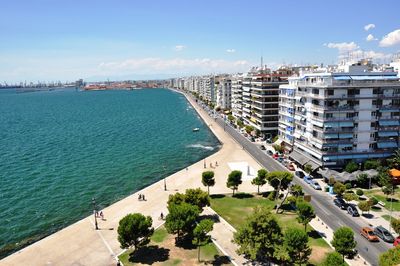 Scenic view of sea by buildings against sky