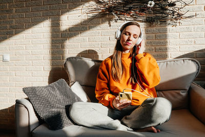 Young woman sitting on sofa at home