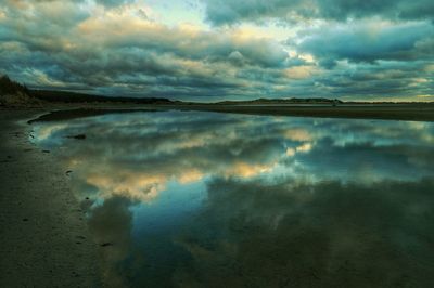 Scenic view of calm sea against cloudy sky