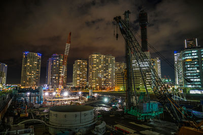 Illuminated modern buildings against sky in city at night