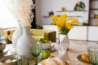 Bright spring mimosa in a ceramic geometric vase in the decor serving a festive or home table 