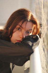 Close-up portrait of woman leaning on railing