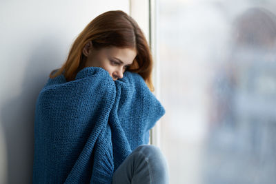 Woman looking away while standing at home