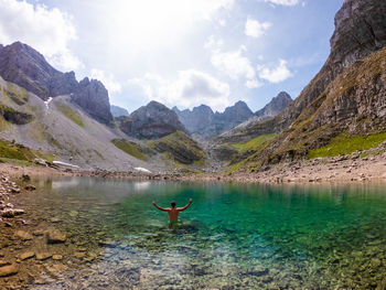 Scenic view of lake by mountains against sky