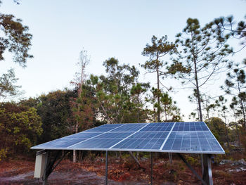 Solar panels on field against sky