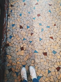 Low section of man standing on tiled floor