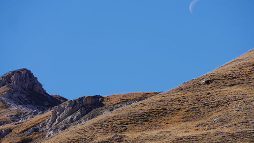 Low angle view of mountain against clear blue sky