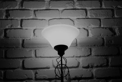 Close-up of illuminated light bulb against wall