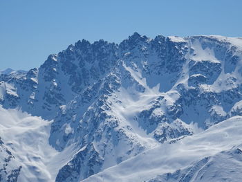 Scenic view of snowcapped mountains against clear sky